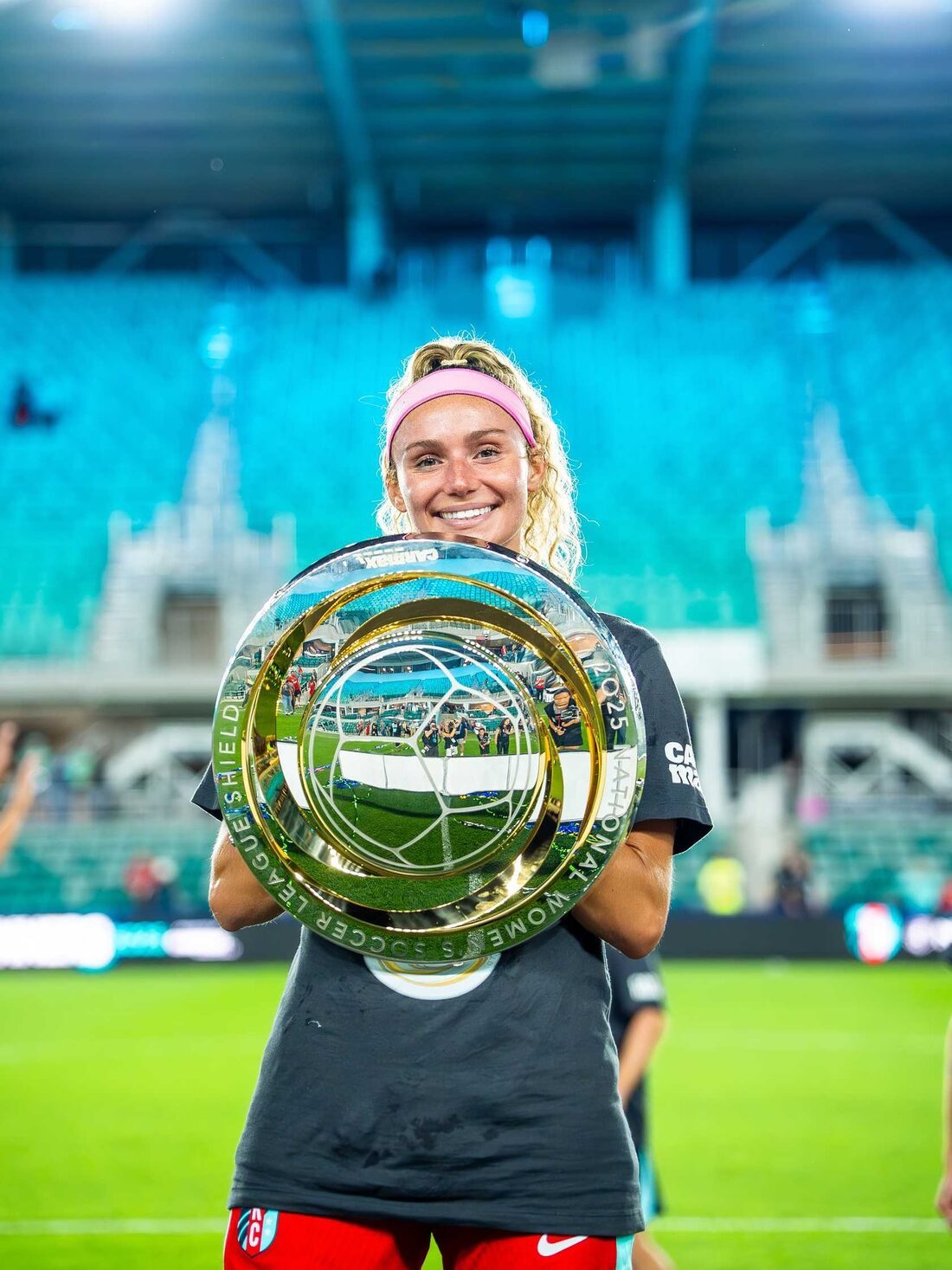 Ellie smiling and holding the 2025 NWSL Shield at CPKC Stadium